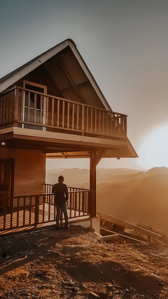 Silhouette of a person on a balcony with a stunning sunset over Panamanian hills.